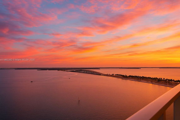Panoramic view of a bridge and sunset over the water from a high vantage point.