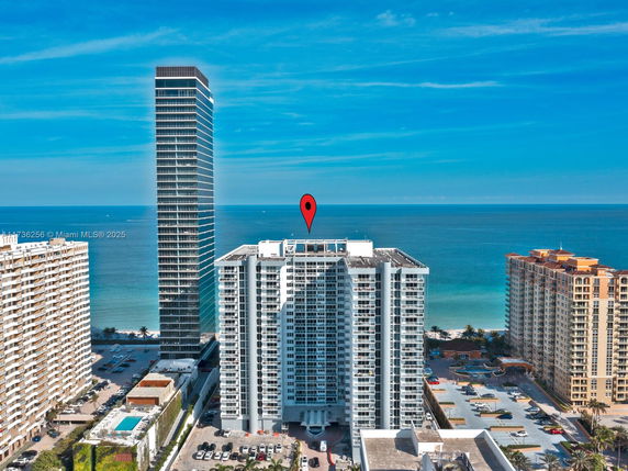 Panoramic view of tall buildings by the ocean.
