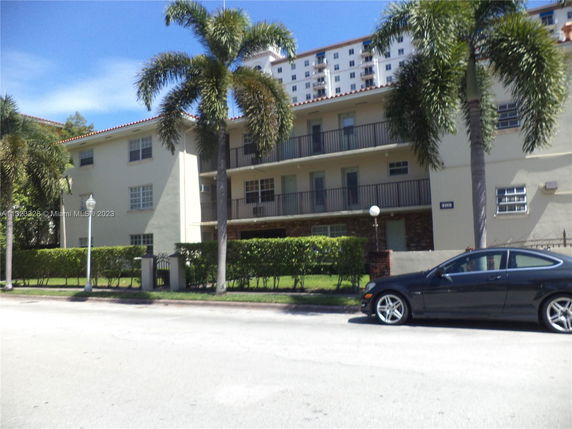 Front view of a multi-story apartment building with balconies.