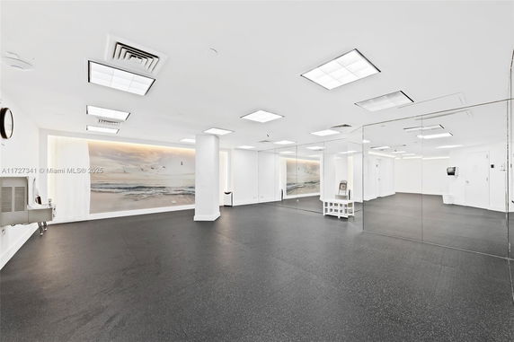 Spacious indoor recreation area with mirrors and mural.