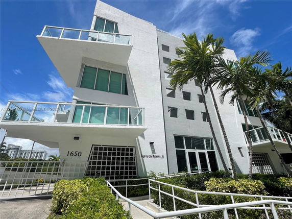 Front view of a multi-story building with balconies and modern design.