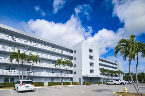 Front view of a multi-story apartment building with balconies.