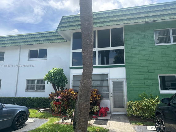 Front view of a two-story building with green and white exterior.