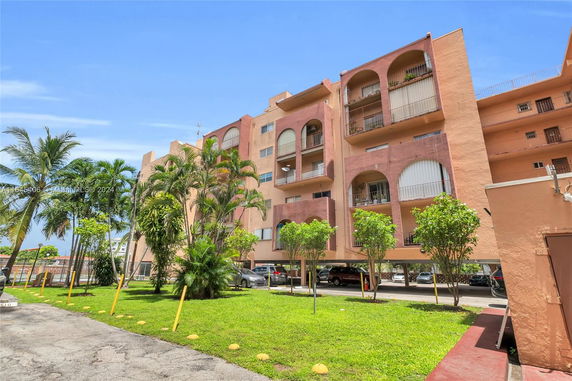 Front view of a multi-story apartment building with arched balconies.
