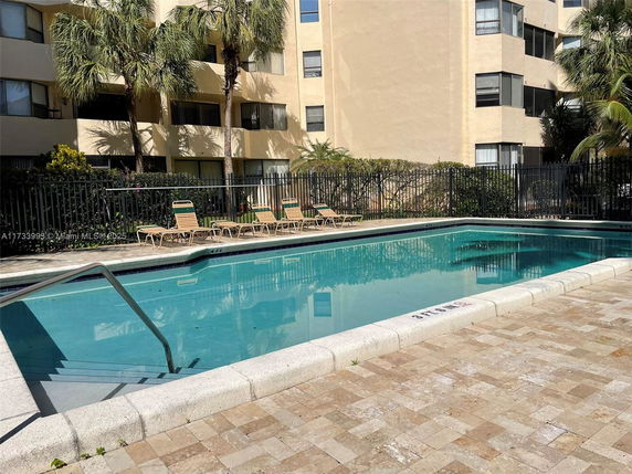 Outdoor swimming pool beside a multi-story building.