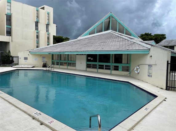Outdoor view of a building with a swimming pool in front.