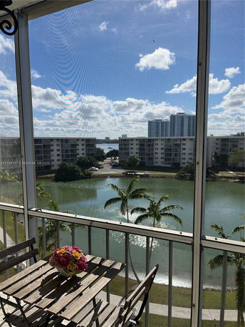 View of surrounding buildings, water, and trees from a balcony.