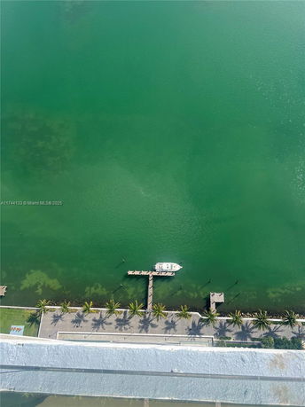 Aerial view of a waterfront area with a dock and a boat.