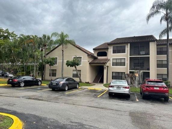 Outdoor parking area in front of a multi-story residential building.