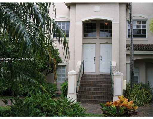 Front view of a two-story building with a double entrance and staircase.