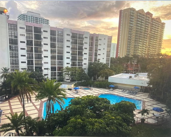 View of apartment buildings with a swimming pool in the foreground.