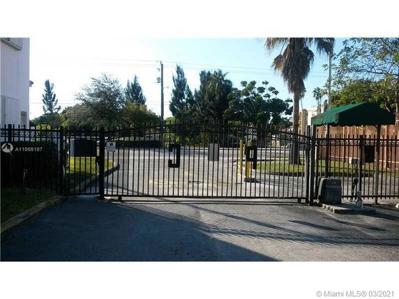 Outdoor parking area with a gated entrance.
