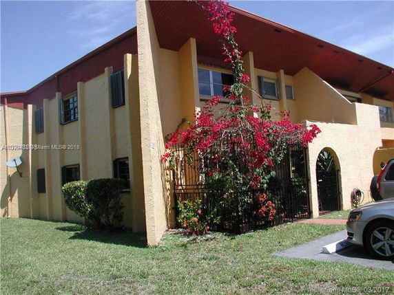 Front view of a two-story building with arched entrances and red accents.