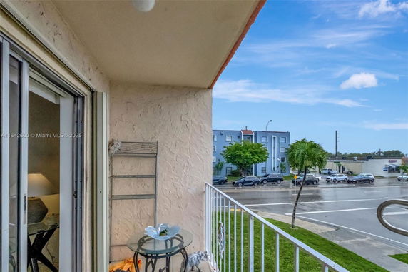 Balcony view highlighting surrounding neighborhood and street from an apartment.
