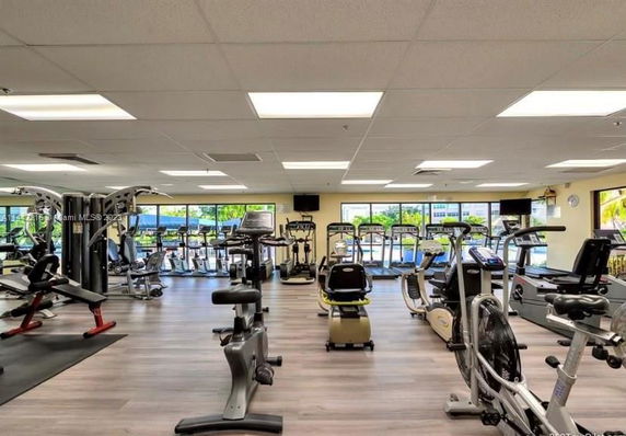 Indoor gym area with exercise equipment and large windows.