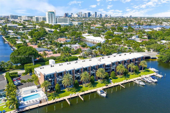 Panoramic view of waterside residential building with apartments and boats docked along a canal.