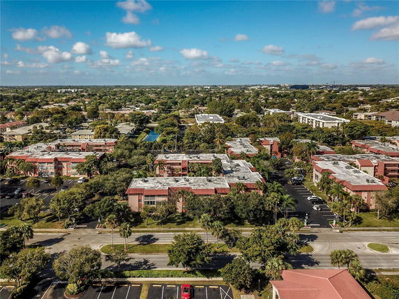 Aerial view of multiple residential buildings with flat roofs in a suburban area.