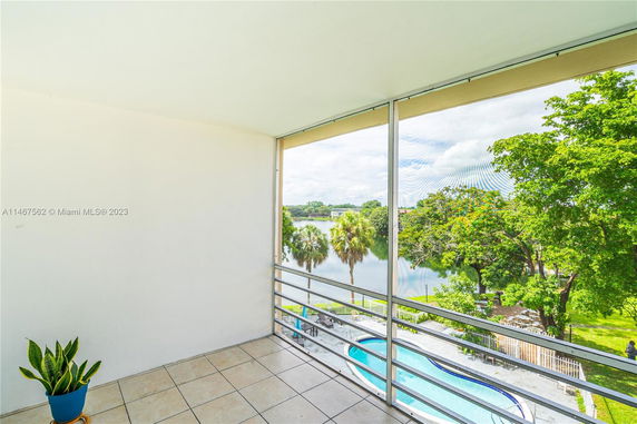 View from a balcony showing trees and a swimming pool.