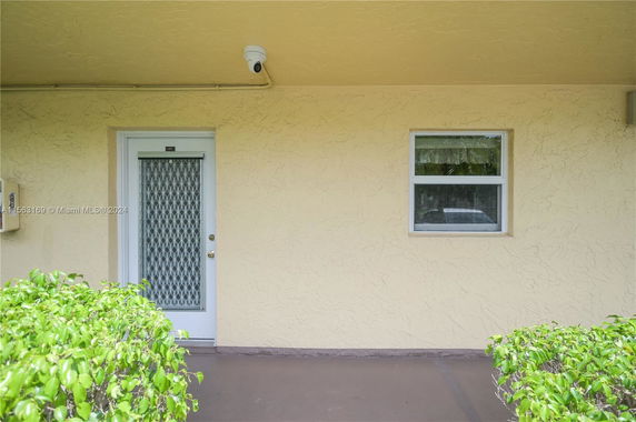 Front view of a building with a metal grid door and a window.