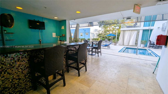 Outdoor area with a pool, seating, and a bar area.