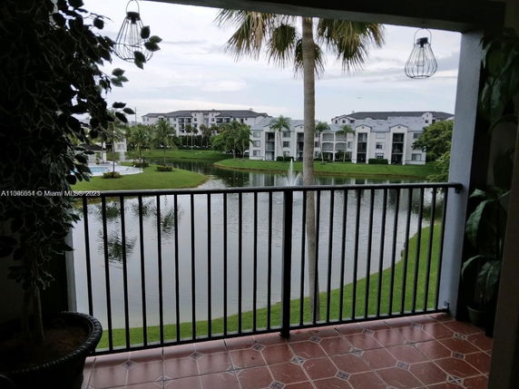 Balcony view overlooking a lake with multi-story residential buildings in the background.