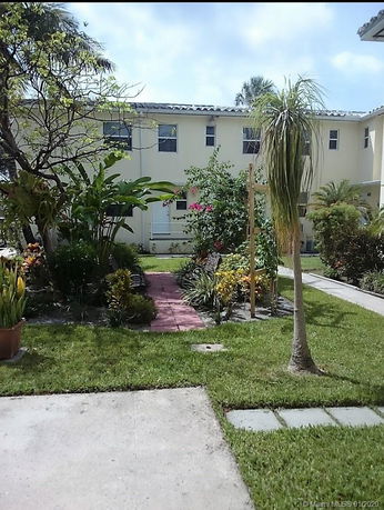Front view of a two-story building with a landscaped garden.