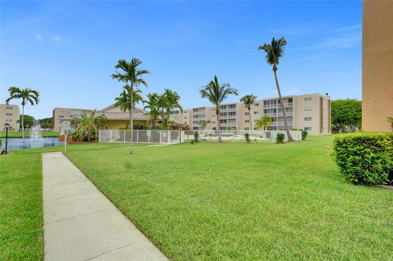 View of surrounding area with multi-story residential buildings and palm trees.