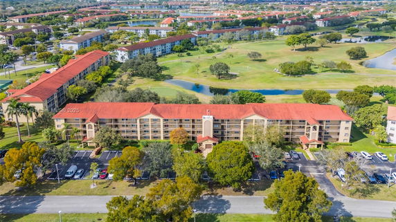 Aerial view of a residential complex with multiple buildings and landscaped areas with water features.