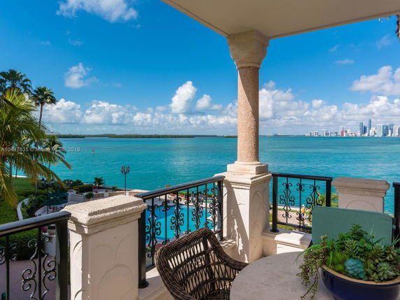 View from a balcony overlooking water with distant city skyline.