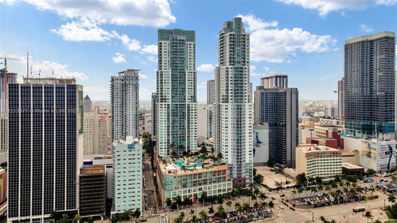 Aerial view of a cityscape featuring multiple high-rise buildings with modern architectural designs.
