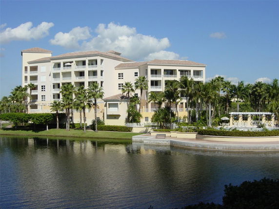 Front view of a multi-story residential building by a lake.