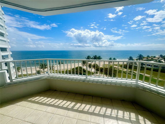Panoramic view of a balcony overlooking the beach and ocean.