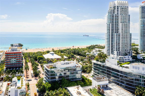 Aerial view of beachfront urban area with tall buildings and ocean.