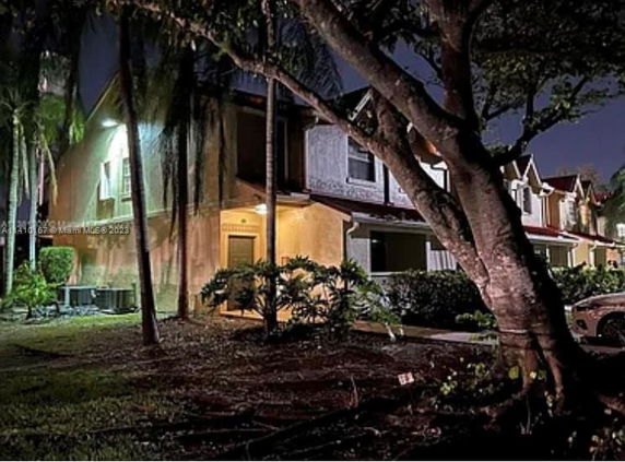 Front view of a two-story house with exterior lighting at night.