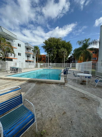 Outdoor swimming pool area with surrounding apartment buildings.