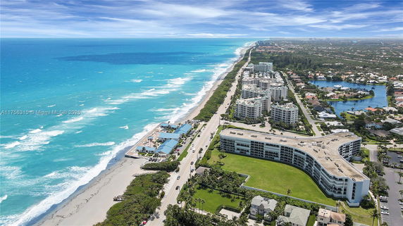 Aerial view of a coastline with oceanfront buildings and a long stretch of beach.