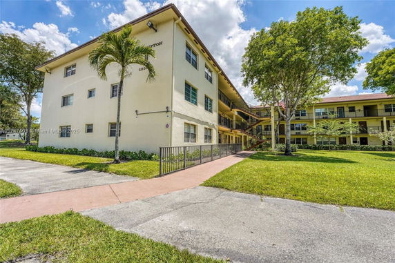Front view of a three-story apartment building with walkways and balconies.