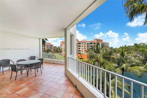 Balcony with a view of surrounding buildings and palm trees.