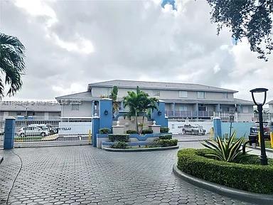 Front view of a multi-story building with entrance gate and fountain.