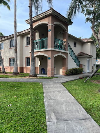 Front view of a two-story house with outdoor staircase and balcony.