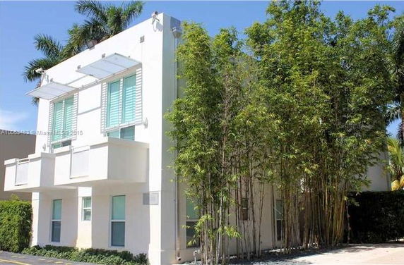 Front view of a modern two-story house with large windows and a flat roof.