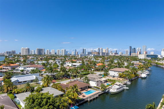 Aerial view of residential and cityscape with waterway and boats.