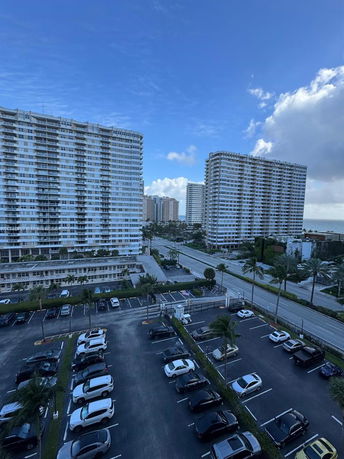 View of multiple high-rise residential buildings with parked cars in the foreground.