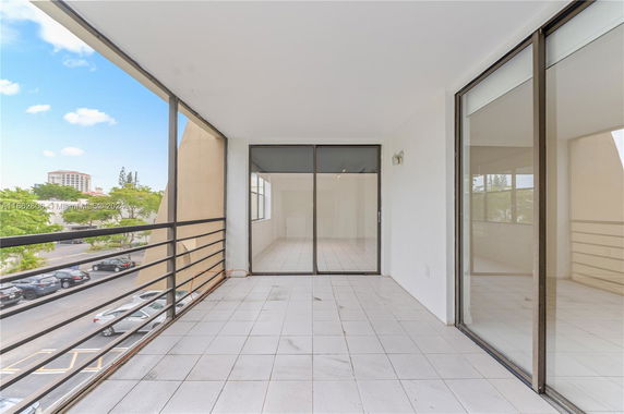 Outdoor balcony area with railing and view of surrounding buildings.