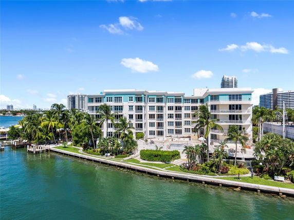 Front view of a multi-story waterfront building with balconies.