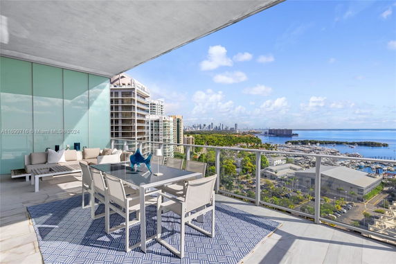 Panoramic view from a balcony overlooking buildings and a waterfront area.