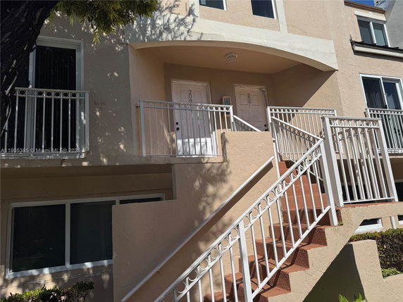 Front view of a multi-story building with two entry doors and stairs.