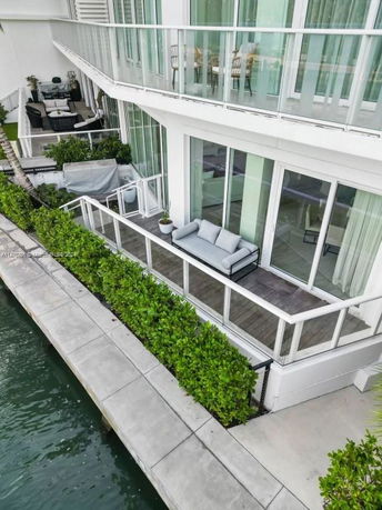 View of modern house balconies with glass railings overlooking a waterway.
