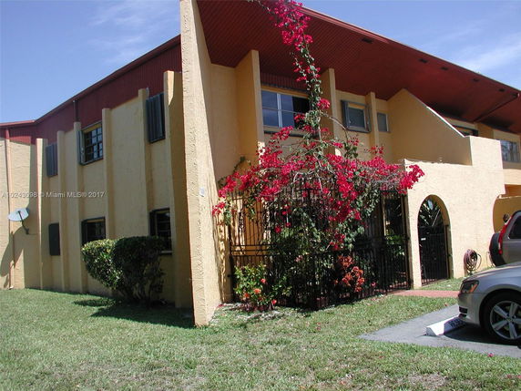 Front view of a two-story house with arched entrance and exterior decorations.