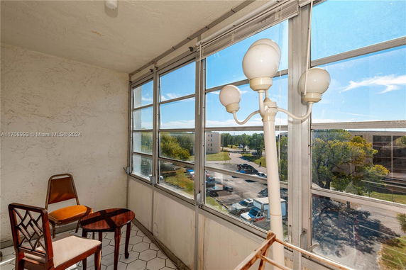 View from a room with windows overlooking a parking area and nearby buildings.